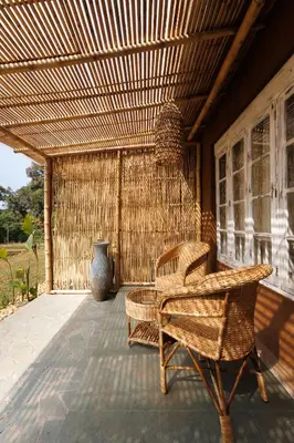 a patio with wicker chairs and a table at Jungle Park Resort-Rain Forest Experience by GreenEscapes in Vythiri