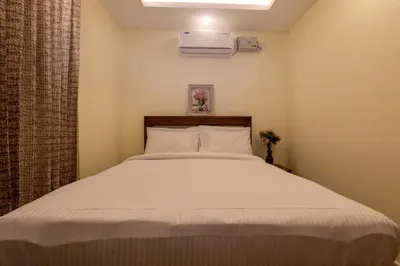 a bedroom with a bed with a white bedspread at The Modern Inn in Pollāchi