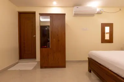 a bedroom with a bed and a door and a window at The Modern Inn in Pollāchi