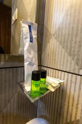 a shelf with two bottles ofagents and a bag at The Modern Inn in Pollāchi