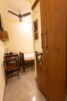 a hallway with a room with a table and a bed at The Modern Inn in Pollāchi