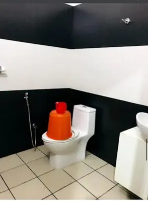 an orange object on a toilet in a bathroom at PLAZA RESIDENCY and CONFERENCE HALL in Malappuram