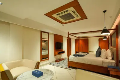 a bedroom with a bed and a living room at Mazarine Hotels & Resorts LLP in Kalpetta