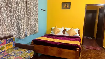a small bedroom with a bed with yellow and blue at Mountain melody cottages in Ooty