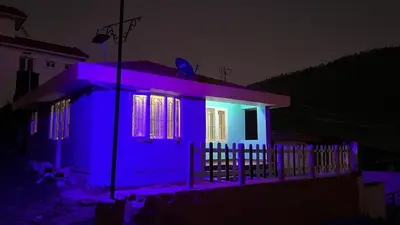 a house lit up in purple and blue at night at Mountain melody cottages in Ooty