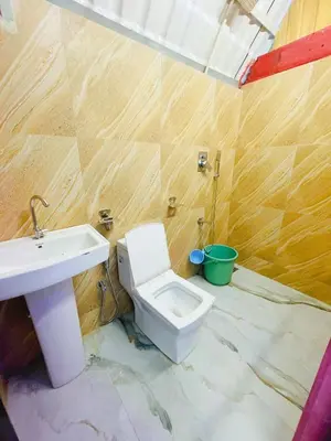 a bathroom with a white toilet and a sink at LAKSHMI NIKUNj Estate Stay in Madikeri