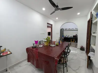 a dining room with a table and a ceiling fan at Thekkumkattil Villa in Nedumbassery