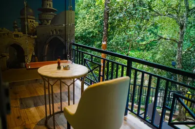 a balcony with a table and a chair and a window at Hunters Hideout Resort in Wayanad