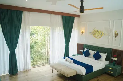 a bedroom with a bed and a large window at Hunters Hideout Resort in Wayanad
