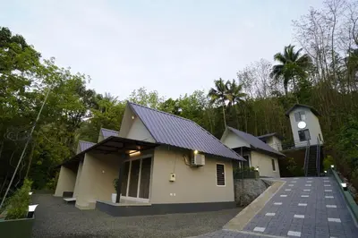 a house with a black roof and a driveway at Elephant Village Private Pool Villa in Munnar