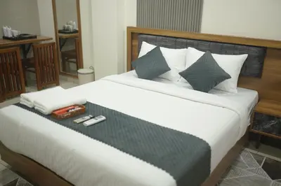 a bedroom with a bed with a tray with a cell phone at Cruz Inn calicut in Kozhikode