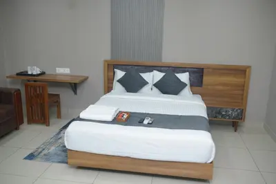 a bedroom with a large bed with a wooden headboard at Cruz Inn calicut in Kozhikode