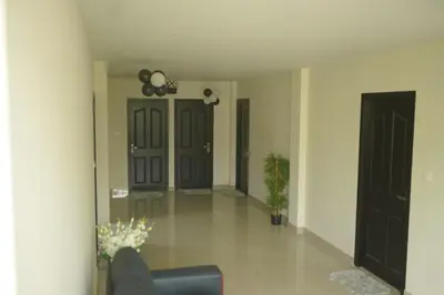 a living room with black doors and a chair at Cruz Inn calicut in Kozhikode