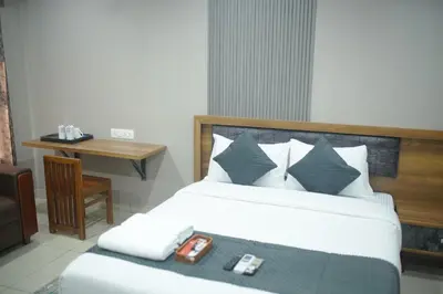 a bedroom with a bed with two remote controls on it at Cruz Inn calicut in Kozhikode
