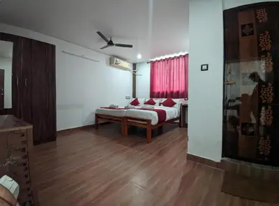 a living room with a bed and a window at Skyry Hotels Singanallur in Coimbatore