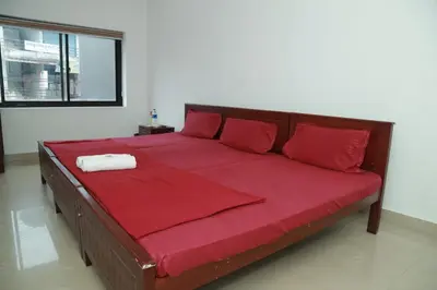 a large bed with red sheets and a red blanket at Royal Park in Wayanad