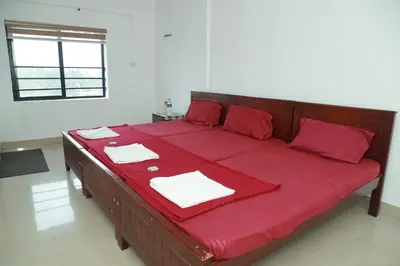 a large red bed with red sheets and napkins on it at Royal Park in Wayanad