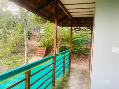 a view from the inside of a house with a blue railing at Happydays Hut in Mananthavady