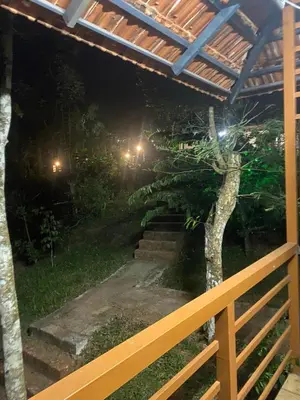 a backyard at night with a fence and a tree at Happydays Hut in Mananthavady