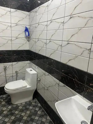 a bathroom with a white toilet and a sink at Happydays Hut in Mananthavady