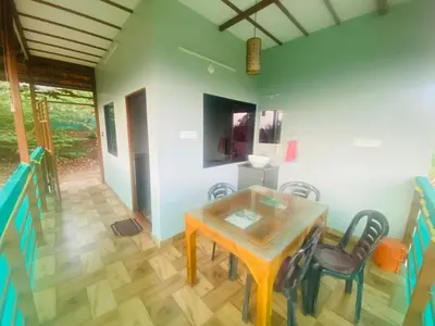 a dining room with a table and chairs at Happydays Hut in Mananthavady
