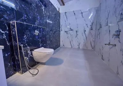 a bathroom with a toilet and a blue marble wall at Shivvs Heritage Resort Ooty in Ooty