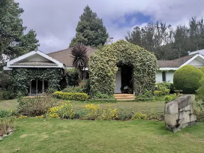 a house with ivy on the front of it at Hideaway in Ooty