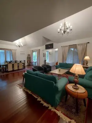 a living room with green couches and a table at Hideaway in Ooty