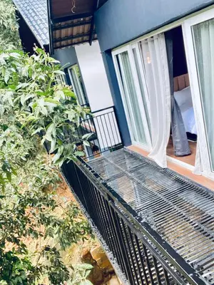 a balcony of a house with a metal grate on it at SR Villa - Serenity by riverside in Meppādi