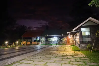 a house at night with lights on the street at The Rain Tree resort in Kutta