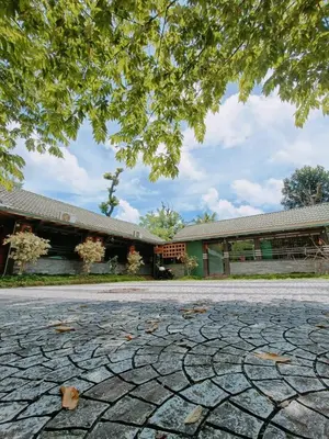 a building with a stone driveway in front of a building at The Rain Tree resort in Kutta