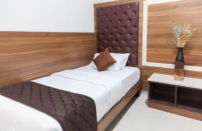 a bedroom with a bed and a vase with flowers at Ananyas Nest in Coimbatore