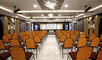 a room with rows of chairs and a screen at Ananyas Nest in Coimbatore