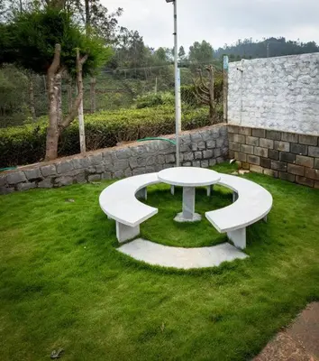 a bench sitting in the grass in a yard at Haven inn in Kotagiri