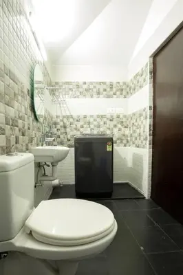 a bathroom with a toilet and a sink at Haven inn in Kotagiri