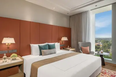 a hotel room with a large bed and a window at Taj Cochin International Airport, Kerala in Cochin