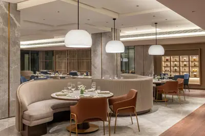 a restaurant with tables and chairs and lights at Taj Cochin International Airport, Kerala in Cochin
