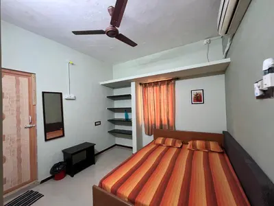 a bedroom with a bed and a ceiling fan at SHI's 2BHK home in Coimbatore near Sai Baba Colony, Ganga C Hospital, Women's care in Coimbatore