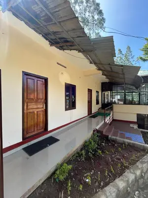 a home with a wooden door and a patio at GV Royal Residency Vattavada in Vattavada