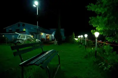a park bench sitting in the grass at night at Cliff Club Resort Ooty in Ooty