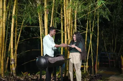 a man and a woman standing in front of bamboo at Ayurnest Pool Resort Wayanad in Batheri