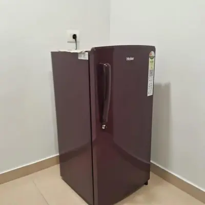a black refrigerator sitting in a room at Seashells Pentagon Calicutbeach in Kozhikode