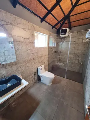 a bathroom with a toilet and a shower and a sink at KK Selfie Point Resort in Coimbatore
