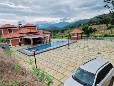 a car parked in front of a house with a swimming pool at KK Selfie Point Resort in Coimbatore