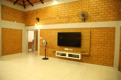 a room with a brick wall with a flat screen tv at KK Selfie Point Resort in Coimbatore