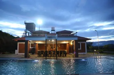 a house with a swimming pool in front of a house at KK Selfie Point Resort in Coimbatore