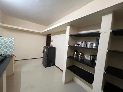 a room with a kitchen with a refrigerator and shelves at SHI's 2bhk Near Ganga Hospital in Coimbatore