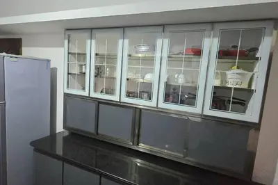 a kitchen with white cabinets and a refrigerator at Entire 4 Bedroom Villa in Kannur in Edakkād