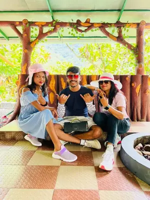 a group of three people sitting on a bench at Holy Village Homestay in Neriyamangalam