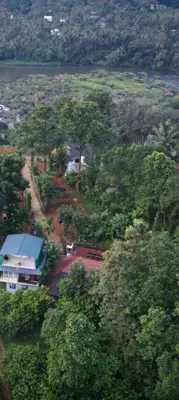 a house in the middle of a forest of trees at Holy Village Homestay in Neriyamangalam